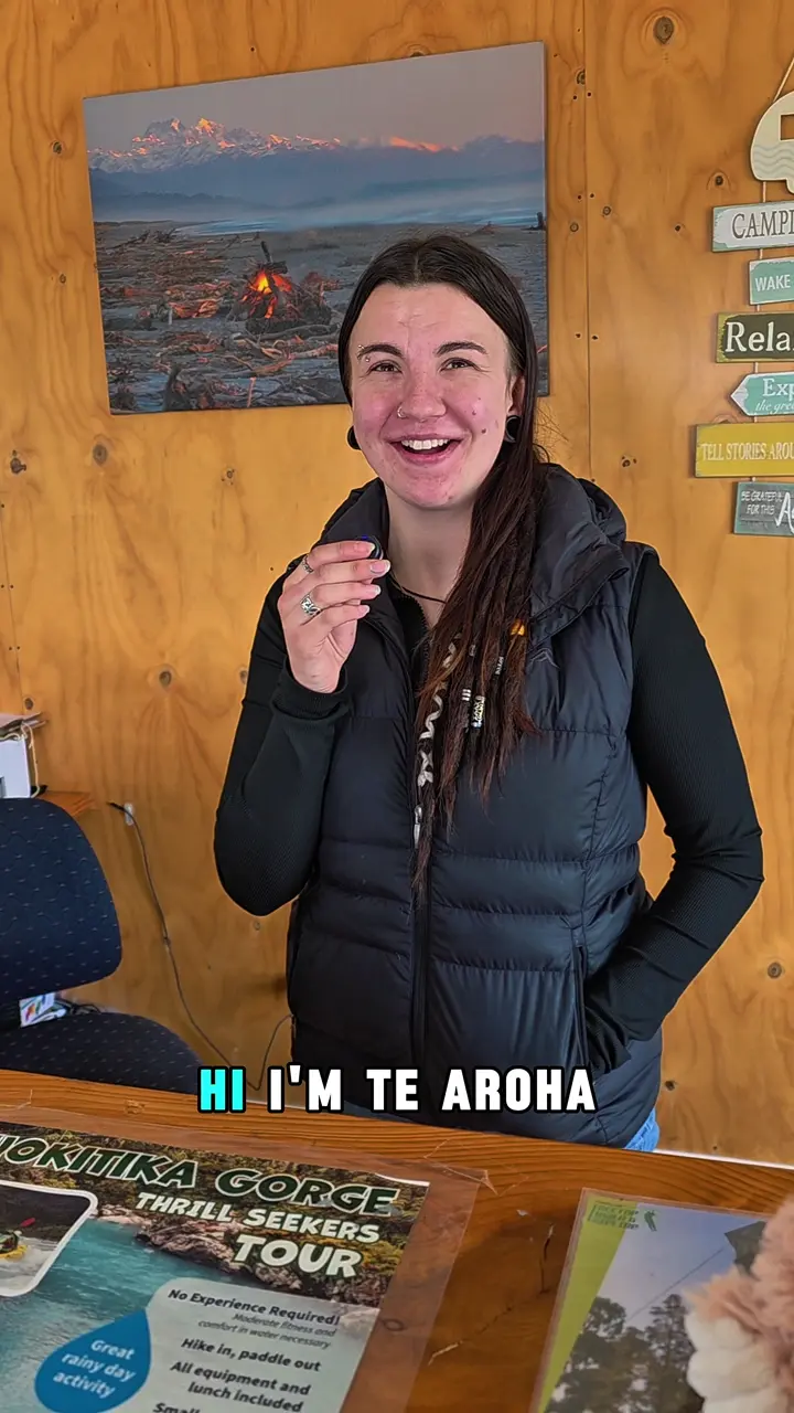 A member of the Hokitika Holiday Park team welcoming visitors at reception