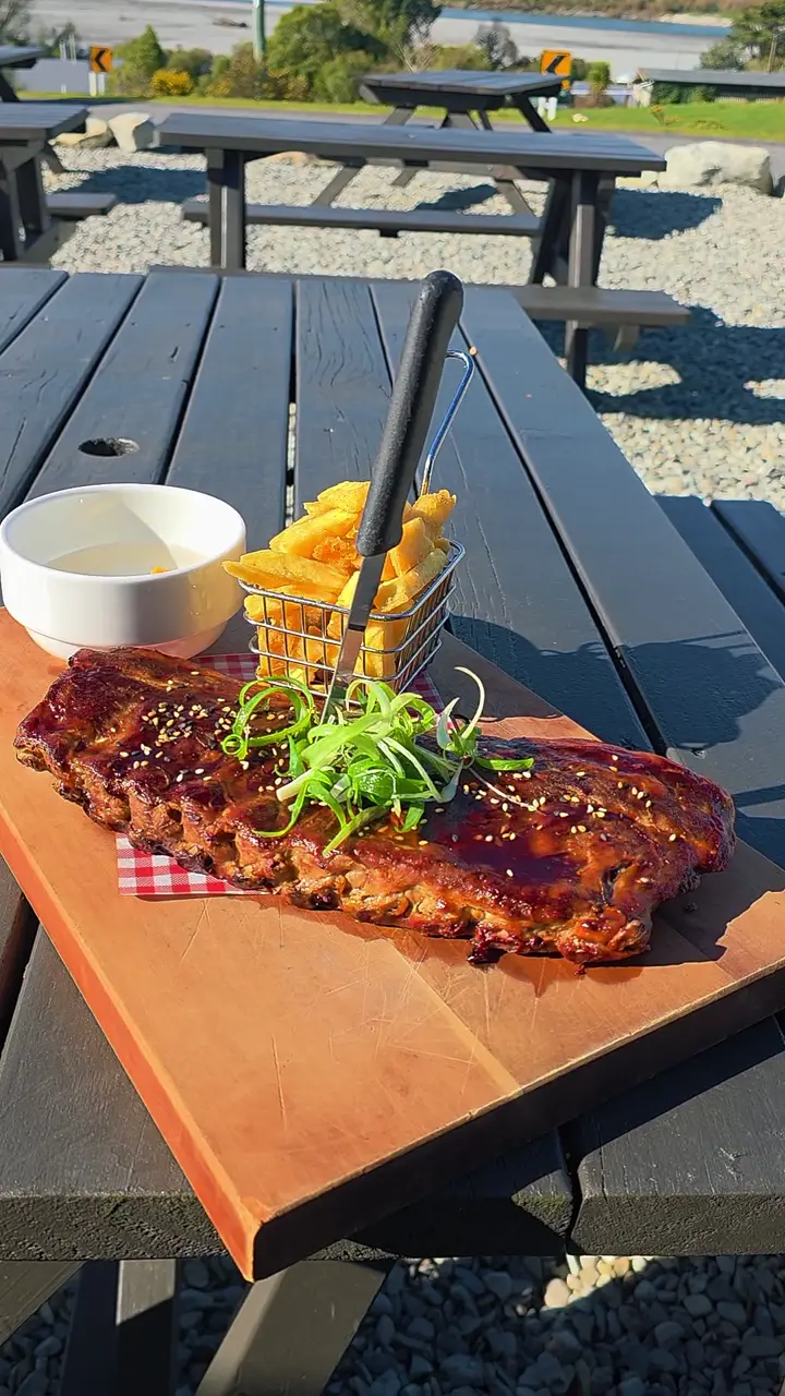 Ribs and chips served on a wooden board outside Woodstock Hotel